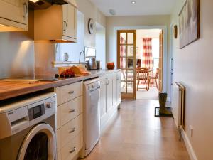a kitchen with a washer and dryer in it at The Byre in Kirkcudbright