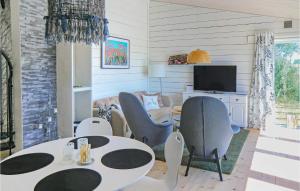 卡爾馬的住宿－Amazing Home In Kalmar With House Sea View，客厅配有2张桌子和椅子以及电视