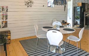 Amazing Home In Kalmar With House Sea View في كالمار: غرفة بثلاث طاولات وكراسي بيضاء