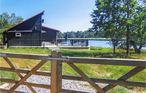 a barn with a fence in front of a lake at Stunning Home In Kalmar With 2 Bedrooms And Wifi in Kalmar