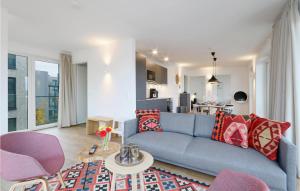 a living room with a blue couch and a kitchen at Beach Front Apartment in Lembruch