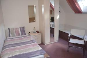a small bedroom with a bed and a desk at Guesthouse AirMinis in Düsseldorf
