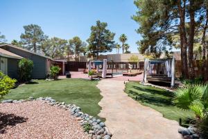 einen Hinterhof mit einem Garten mit einem Spielplatz in der Unterkunft Resort-Style Paradise w 2 Pools in Las Vegas