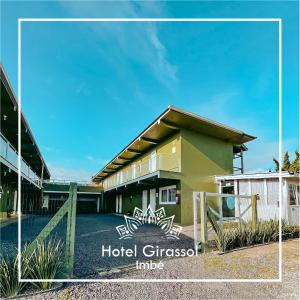 ein Gebäude mit einem Schild, das Hotel giscos Inn liest in der Unterkunft Hotel Girassol in Imbé