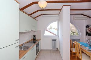 una cocina con armarios blancos y una ventana en Villa Dalmatia, en Zadar