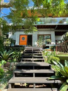 ein Haus mit Holztreppe davor in der Unterkunft Tranquil Garden Apartment with living room in Wollongong