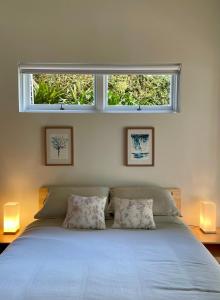 Un dormitorio con una cama y una ventana encima. en Tranquil Garden Apartment with living room, en Wollongong