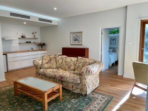 a living room with a couch and a table at Tranquil Garden Apartment with living room in Wollongong