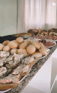 un buffet con platos de comida en una mesa en Hotel Girassol, en Imbé