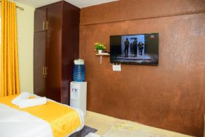 Pokój z łóżkiem i telewizorem na ścianie w obiekcie Elegant studio apartment w mieście Kitengela 