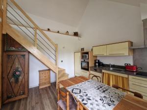 une cuisine avec un escalier et une table dans une pièce dans l'établissement Finistère house 15 minutes from the bay of Morlaix, 