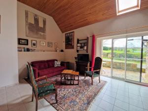 - un salon avec un canapé rouge et une table dans l'établissement Finistère house 15 minutes from the bay of Morlaix, 