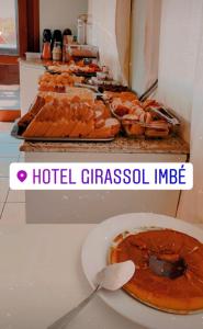 ein Buffet mit Hot Dogs und eine Pizza auf dem Tisch in der Unterkunft Hotel Girassol in Imbé
