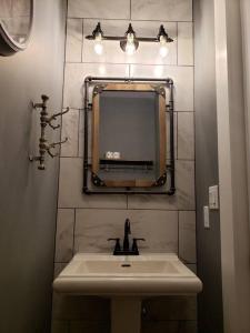 ein Bad mit einem Waschbecken und einem Spiegel in der Unterkunft Urban Lofts in Perryville