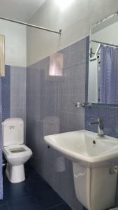 bagno con servizi igienici bianchi e lavandino di Ralph recedency a Kochchikade