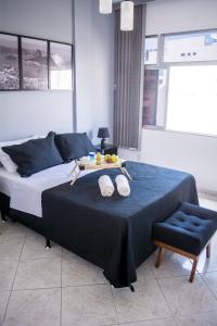 a bedroom with a bed with a tray of fruit on it at Aconchego do Flamengo in Rio de Janeiro