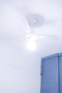 a ceiling fan in a room with a blue door at Aconchego do Flamengo in Rio de Janeiro