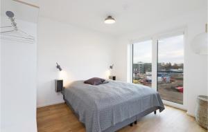 ein weißes Schlafzimmer mit einem Bett und einem großen Fenster in der Unterkunft Beach Front Apartment in Lembruch