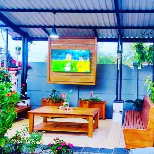 a patio with a table and a tv on a blue wall at Casa Los Madriz Suite #2 in San Isidro
