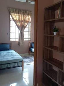 a bedroom with a bed and a book shelf at Nafili homestay 3bd 2br in Kota Bharu