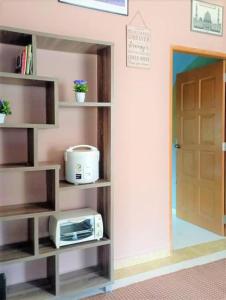 a room with a door and a microwave on a shelf at Nafili homestay 3bd 2br in Kota Bharu