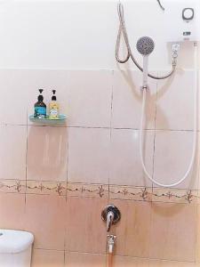 um chuveiro na casa de banho com uma cabeça de chuveiro em Nafili homestay 3bd 2br em Kota Bharu