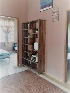 a living room with a book shelf with a radio at Nafili homestay 3bd 2br in Kota Bharu +17 photos