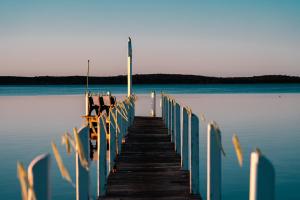 a dock on a body of water with chairs on it at Waterfront Retreat At Wattle Point in Paynesville