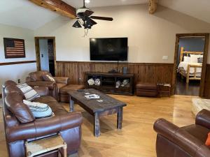 ベルネにあるBoerne Mountain Retreatの革張りの家具と薄型テレビを備えたリビングルーム