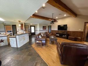 ベルネにあるBoerne Mountain Retreatの広いリビングルーム(革張りの家具付)、キッチンが備わります。