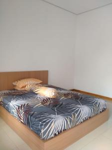 1 cama con marco de madera en una habitación en villa denafa, en Nangela