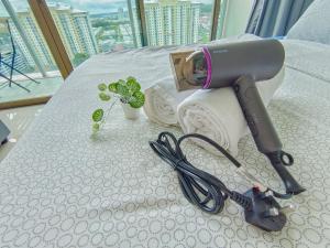 un sèche-cheveux et une paire de ciseaux sur un lit dans l'établissement -Lake View- Mount Austin IKEA Toppen 5 mins - B116, à Johor Bahru