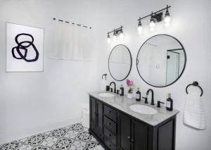 a bathroom with two sinks and two mirrors at Beautifully Updated New Orleans House *sleeps 6* in New Orleans