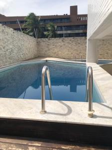 una piscina con dos barras de metal al lado de un edificio en Flat beira mar Manaíra, en João Pessoa