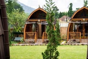 a house with two gazebos in a yard at Kabinku Bali in Bedugul