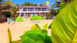 una casa en la playa con estructuras verdes en Gokarna Govekar Beach Stay en Gokarn