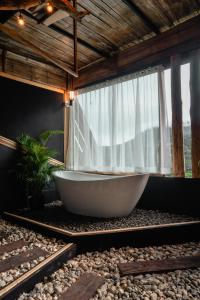 a bath tub sitting in front of a window at JADAE HOUSE Doichang in Ban Huai Khai