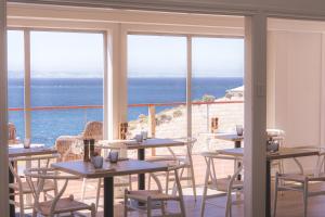 ペネショウにあるSea Dragon Kangaroo Islandのテーブルと椅子が備わり、海の景色を望むレストラン