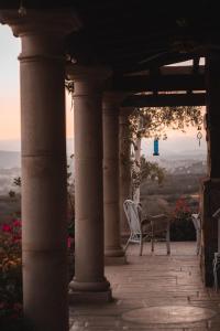une terrasse couverte avec une table et une chaise. dans l'établissement Viña Calabria, à Valle de Guadalupe