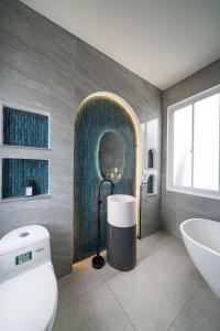 萬隆的住宿－IMAH DHARMA，带浴缸、盥洗盆和卫生间的浴室