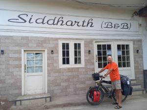 阿姆利則的住宿－Siddharth BnB - Near Golden Temple，把自行车停在建筑物前的人