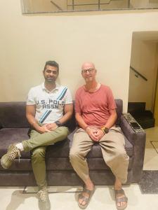 two men sitting on a couch posing for a picture at Siddharth BnB - Near Golden Temple in Amritsar