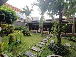 een tuin voor een huis met palmbomen bij Rumah Kami Guest House in Yogyakarta