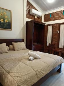 een slaapkamer met een bed met een handdoek erop bij Rumah Kami Guest House in Yogyakarta