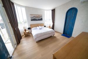 バンドンにあるIMAH DHARMAのベッドルーム1室(白いシーツと青いカーテンのベッド1台付)