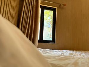 um quarto com uma cama e uma janela em Pleiku Homestay em Pleiku