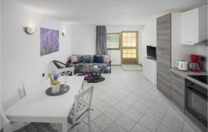 a kitchen and a living room with a couch at One-Bedroom Apartment In Vrsar in Vrsar