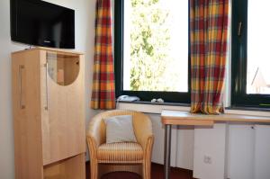 Zimmer mit einem Stuhl, einem Schreibtisch und einem Fenster in der Unterkunft velcrea in Willebadessen