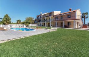 a large house with a swimming pool and a yard at One-Bedroom Apartment In Vrsar in Vrsar