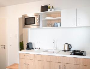 a kitchen with a sink and a microwave at Noble Suite - Parking - Workspace in Gießen +9 photos